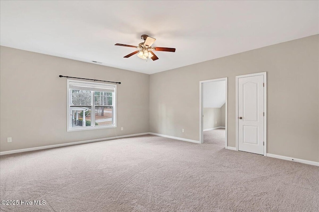 carpeted spare room featuring visible vents, baseboards, and ceiling fan