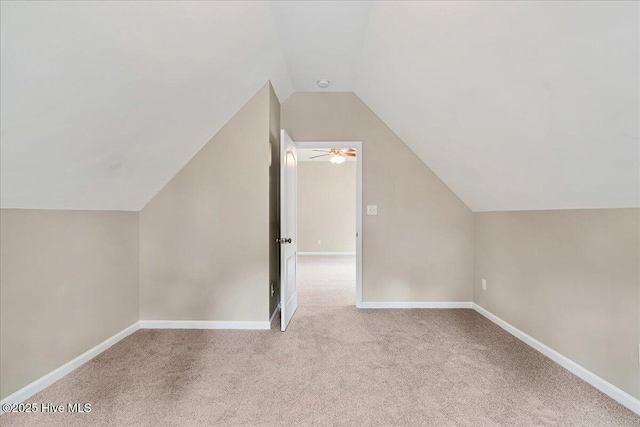 additional living space with vaulted ceiling, carpet, and baseboards