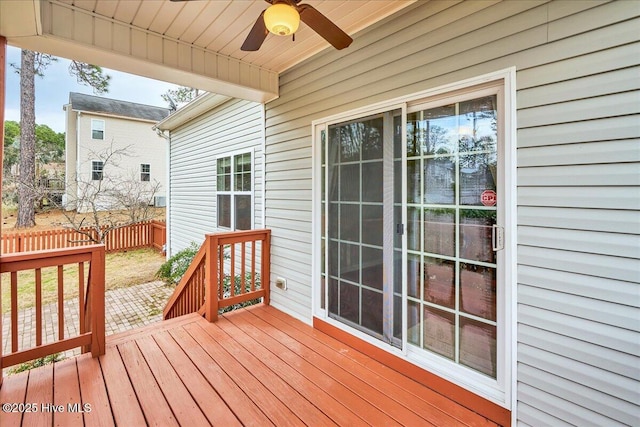 wooden terrace with a ceiling fan and fence