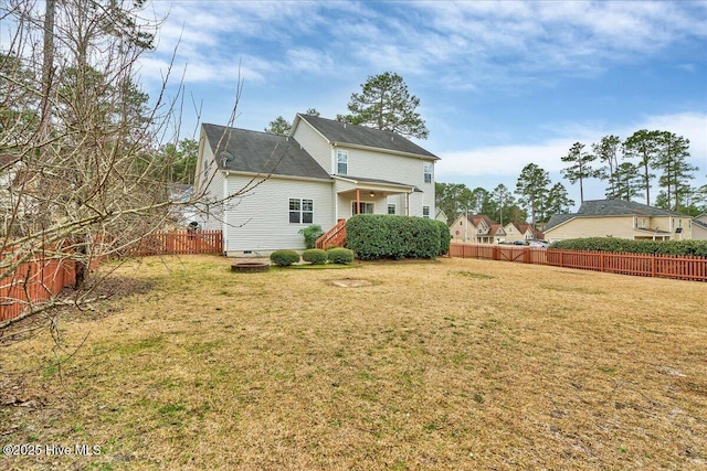 rear view of house with a yard and fence