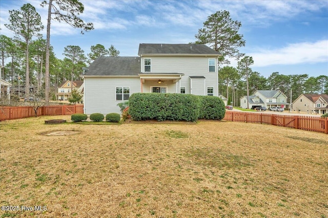 rear view of property featuring a lawn and fence private yard