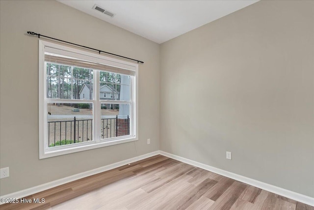 empty room with visible vents, baseboards, and wood finished floors