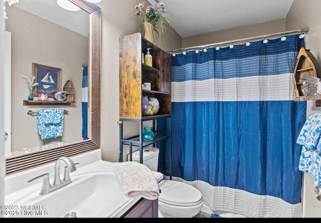 full bath with vanity, a shower with shower curtain, and toilet