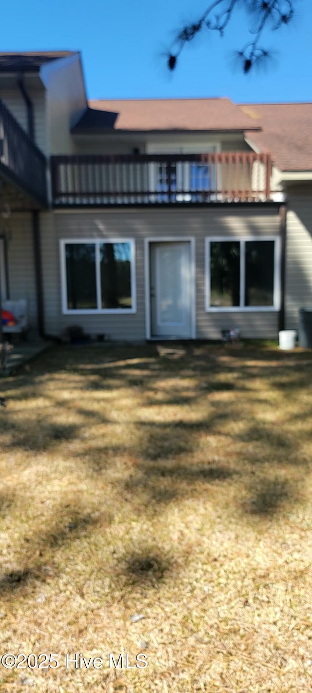 rear view of house featuring a lawn