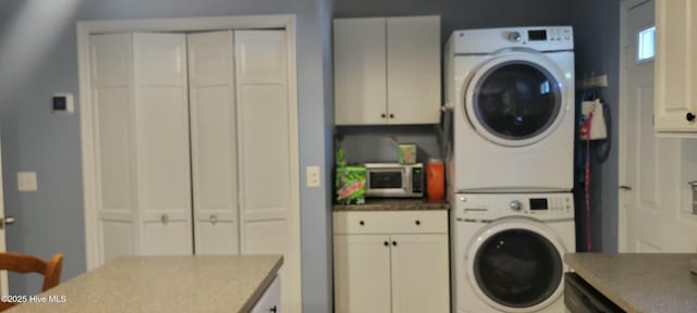 laundry room with cabinet space and stacked washer and dryer