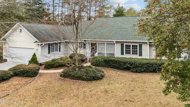 single story home with driveway, a shingled roof, and a front yard