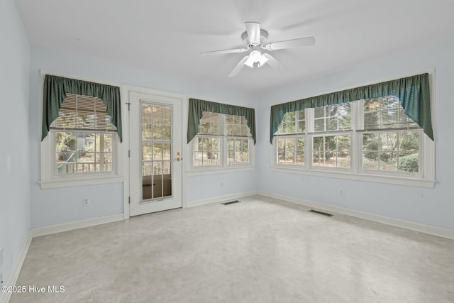 unfurnished sunroom featuring visible vents and a ceiling fan