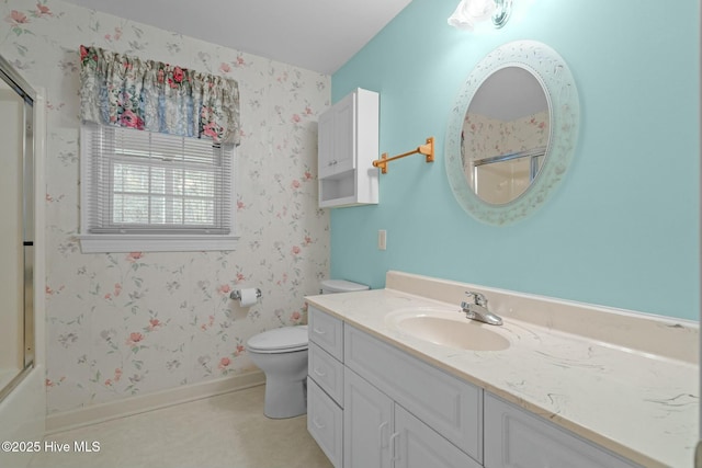 bathroom with toilet, a shower with door, wallpapered walls, baseboards, and vanity