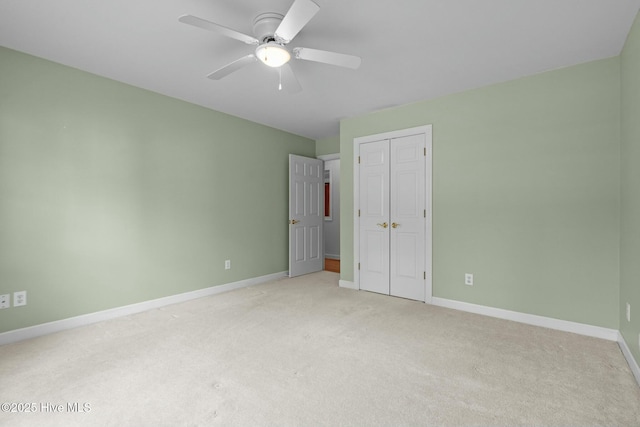 unfurnished bedroom with a closet, light colored carpet, a ceiling fan, and baseboards