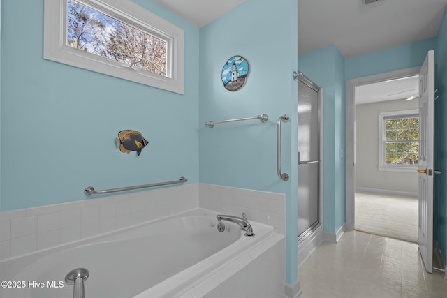 bathroom featuring a stall shower, baseboards, and a garden tub