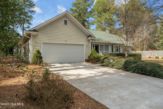 single story home featuring an attached garage, fence, and driveway