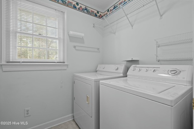 clothes washing area with laundry area, baseboards, and independent washer and dryer