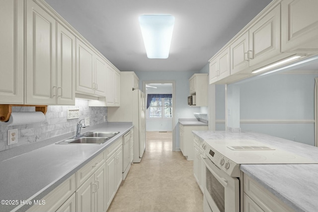 kitchen with white appliances, light floors, a sink, decorative backsplash, and light countertops