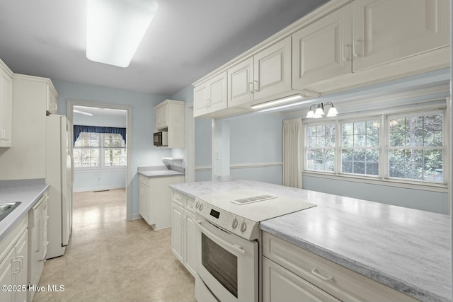 kitchen featuring white appliances, light countertops, and light floors