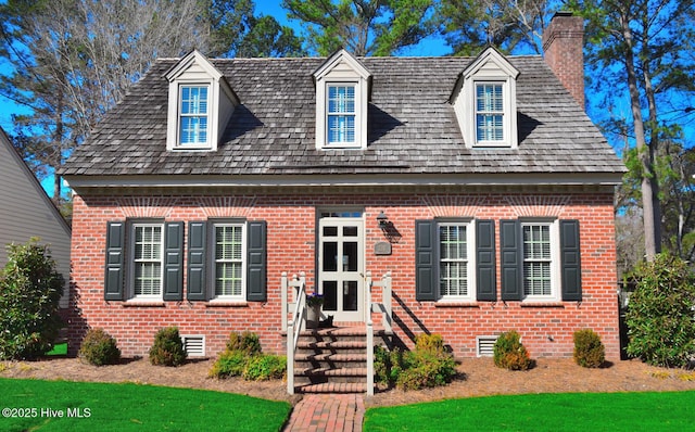 cape cod-style house featuring crawl space, brick siding, and a chimney