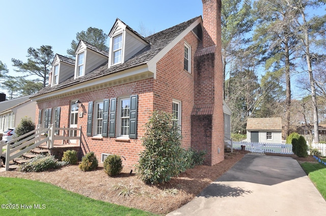 view of side of home featuring brick siding and a chimney