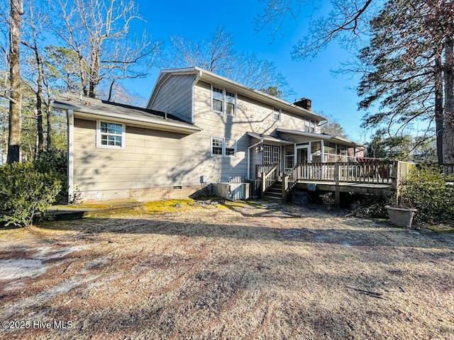 rear view of property featuring crawl space, central air condition unit, a deck, and a chimney