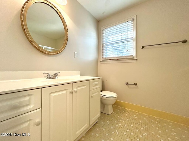 bathroom with vanity, toilet, and baseboards