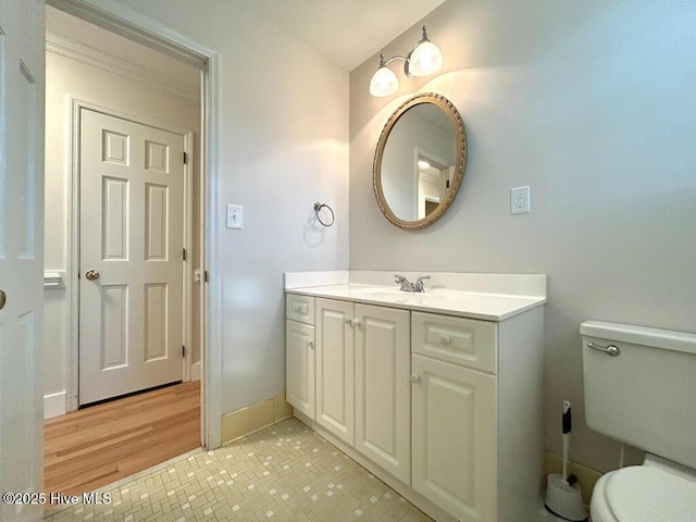 bathroom with tile patterned floors, baseboards, toilet, and vanity