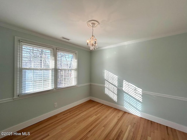 spare room featuring visible vents, light wood-style flooring, baseboards, and an inviting chandelier