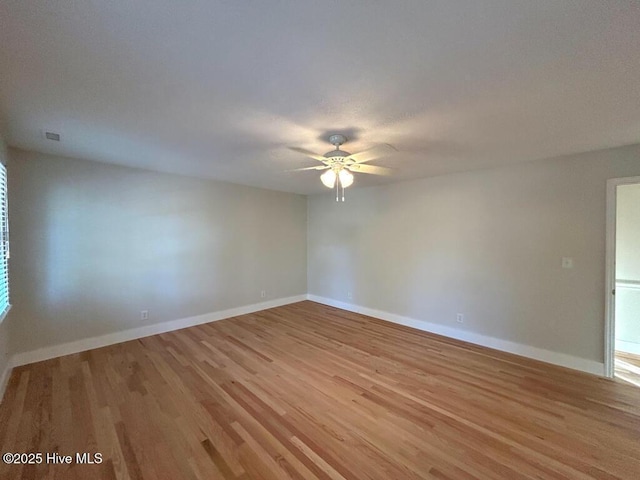 unfurnished room with baseboards, light wood-style flooring, and a ceiling fan