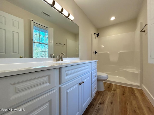 bathroom with visible vents, toilet, vanity, and walk in shower