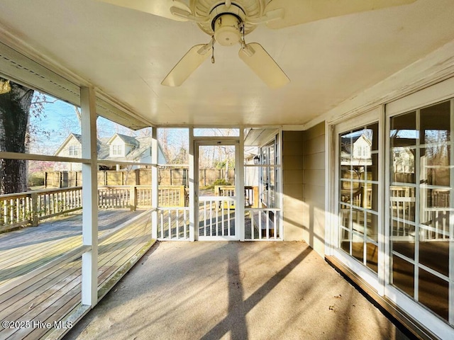 unfurnished sunroom featuring a wealth of natural light and a ceiling fan