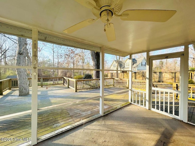 unfurnished sunroom with ceiling fan