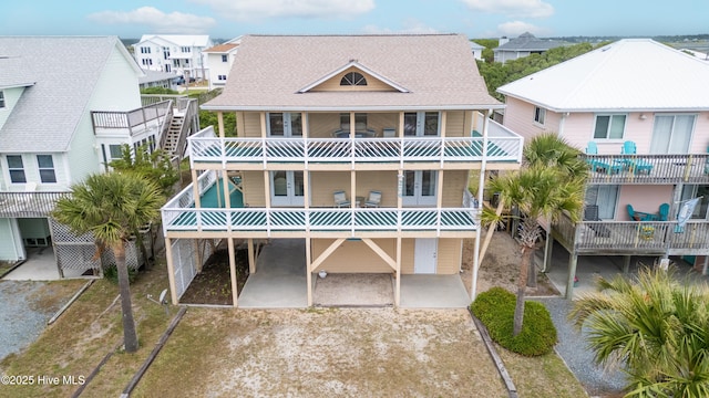 back of house with a balcony, french doors, a residential view, and a shingled roof