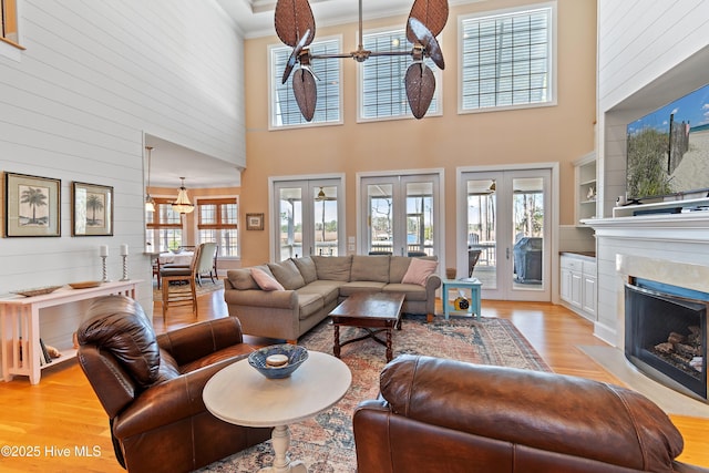 1807 Baywater Ct SE, Bolivia, NC 28422 - living area featuring a towering ceiling, light wood finished floors, a fireplace, wood walls, and ornamental molding