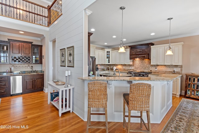 1807 Baywater Ct SE, Bolivia, NC 28422 - kitchen with backsplash, crown molding, a breakfast bar, and light wood-style flooring