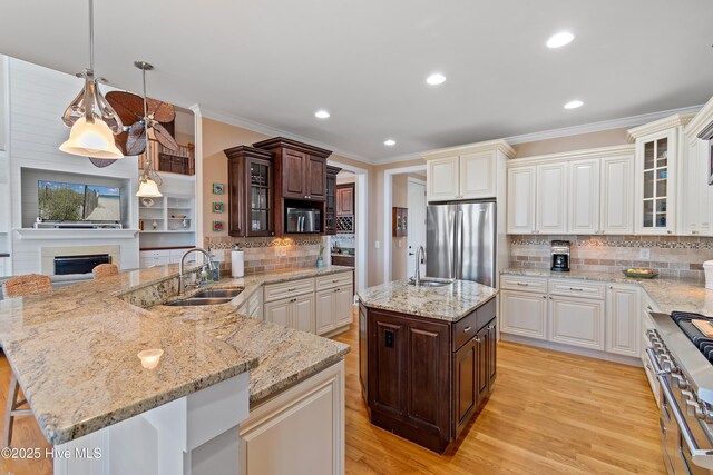 1807 Baywater Ct SE, Bolivia, NC 28422 - kitchen with dark brown cabinetry, a sink, appliances with stainless steel finishes, and crown molding