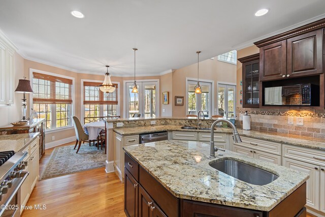 1807 Baywater Ct SE, Bolivia, NC 28422 - kitchen with dark brown cabinetry, appliances with stainless steel finishes, a sink, and light wood-style flooring