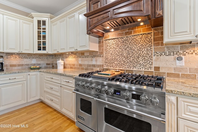 1807 Baywater Ct SE, Bolivia, NC 28422 - kitchen featuring backsplash, light stone countertops, range with two ovens, glass insert cabinets, and custom range hood
