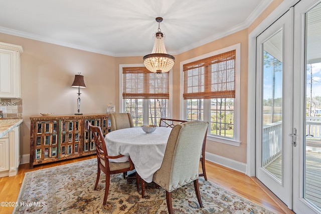 1807 Baywater Ct SE, Bolivia, NC 28422 - dining room with ornamental molding, baseboards, a notable chandelier, and light wood finished floors