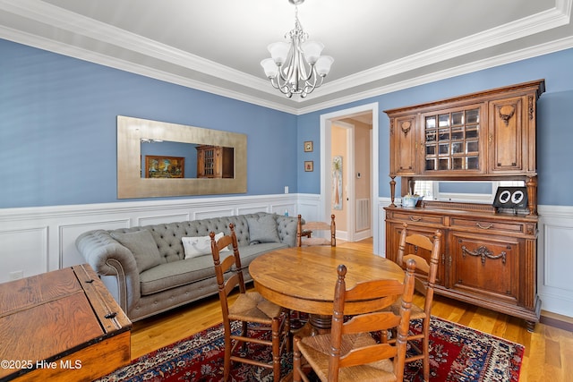 1807 Baywater Ct SE, Bolivia, NC 28422 - dining space with a decorative wall, crown molding, a chandelier, a wainscoted wall, and light wood finished floors