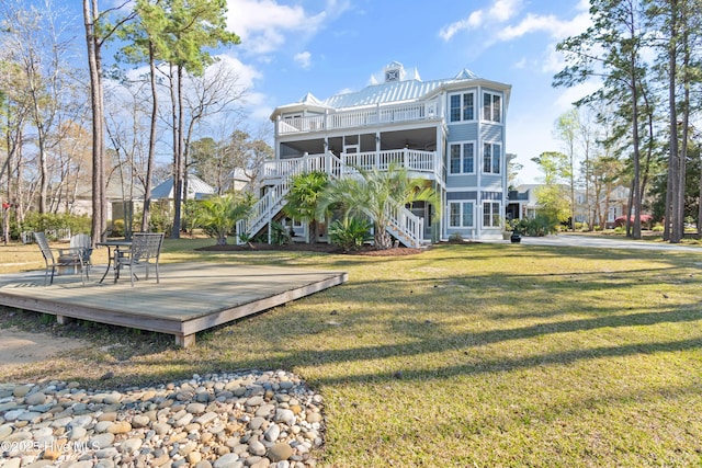1807 Baywater Ct SE, Bolivia, NC 28422 - rear view of house with metal roof, a lawn, stairway, and a deck