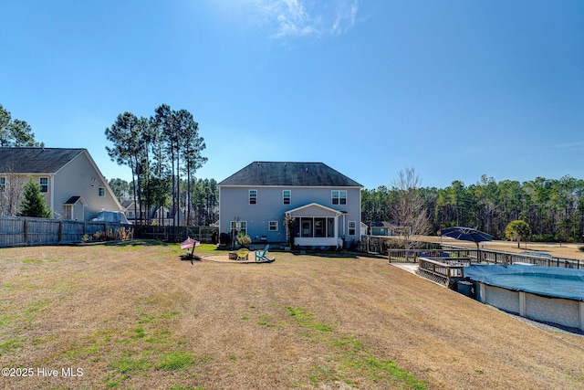 back of house featuring a yard, a fenced in pool, and a fenced backyard