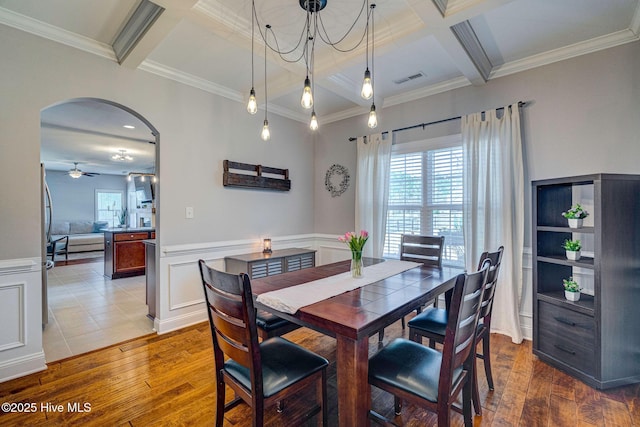 dining space with visible vents, beam ceiling, coffered ceiling, arched walkways, and wood-type flooring