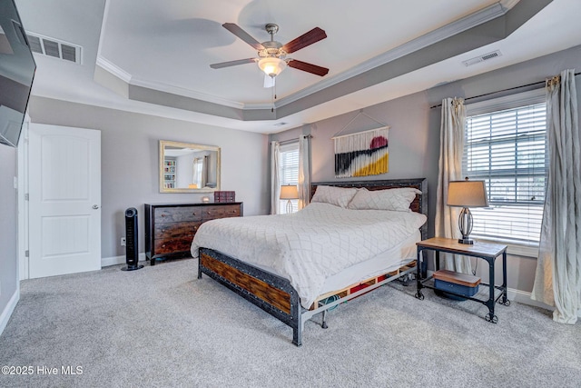 carpeted bedroom featuring a raised ceiling, multiple windows, and visible vents