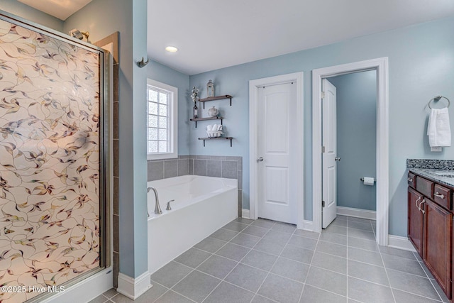 bathroom with tile patterned floors, baseboards, a stall shower, a bath, and vanity