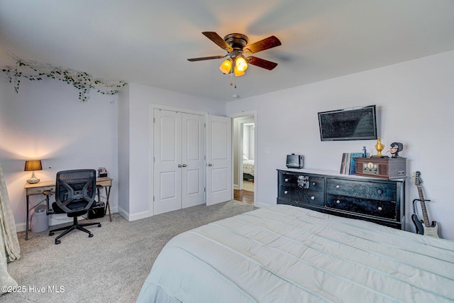 carpeted bedroom featuring a closet, baseboards, and ceiling fan