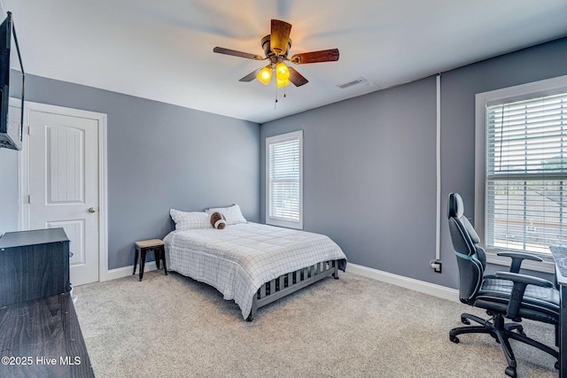 carpeted bedroom featuring baseboards, visible vents, and ceiling fan