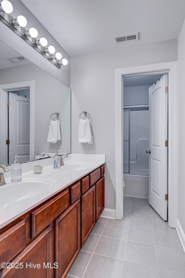 full bathroom with tile patterned floors, double vanity, visible vents, and a sink