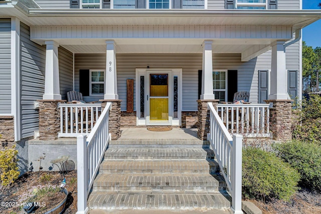 entrance to property with stone siding and covered porch