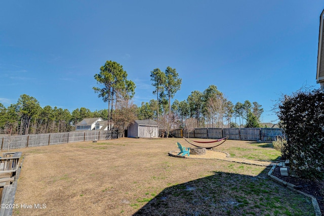 view of yard featuring an outdoor structure, a fenced backyard, and a shed