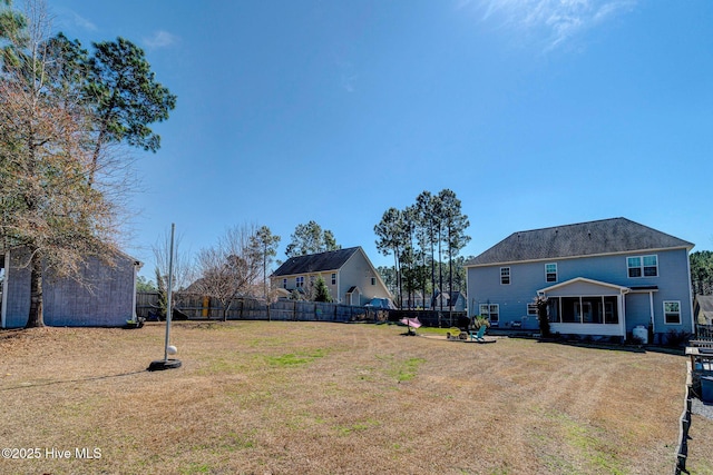 view of yard featuring fence and a sunroom