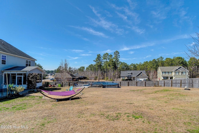 view of yard with a fenced in pool, a fenced backyard, and a sunroom