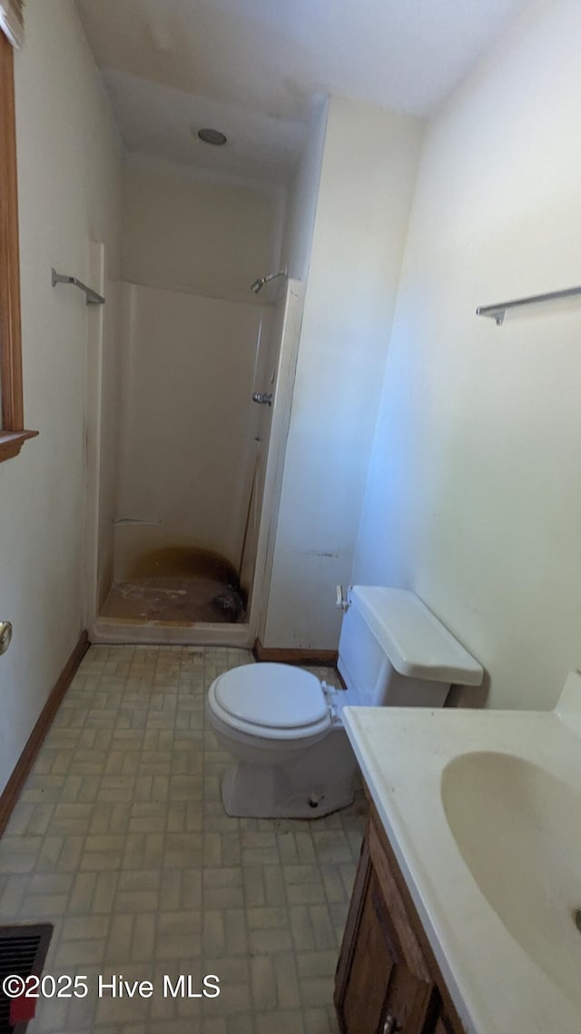 full bath with baseboards, toilet, a stall shower, and vanity