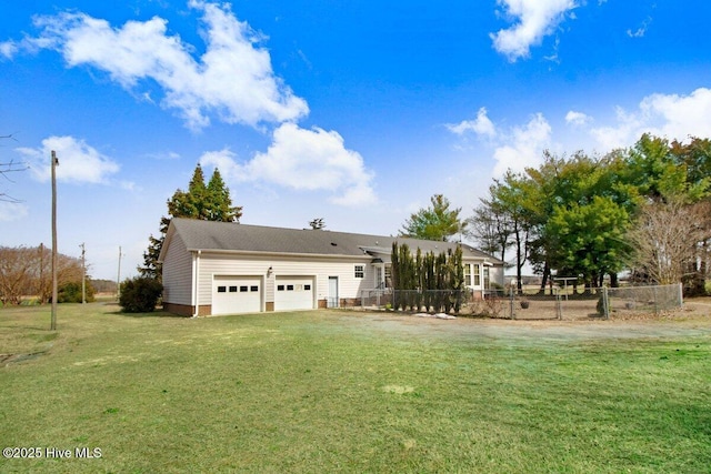 back of property with a yard, fence, a garage, and driveway